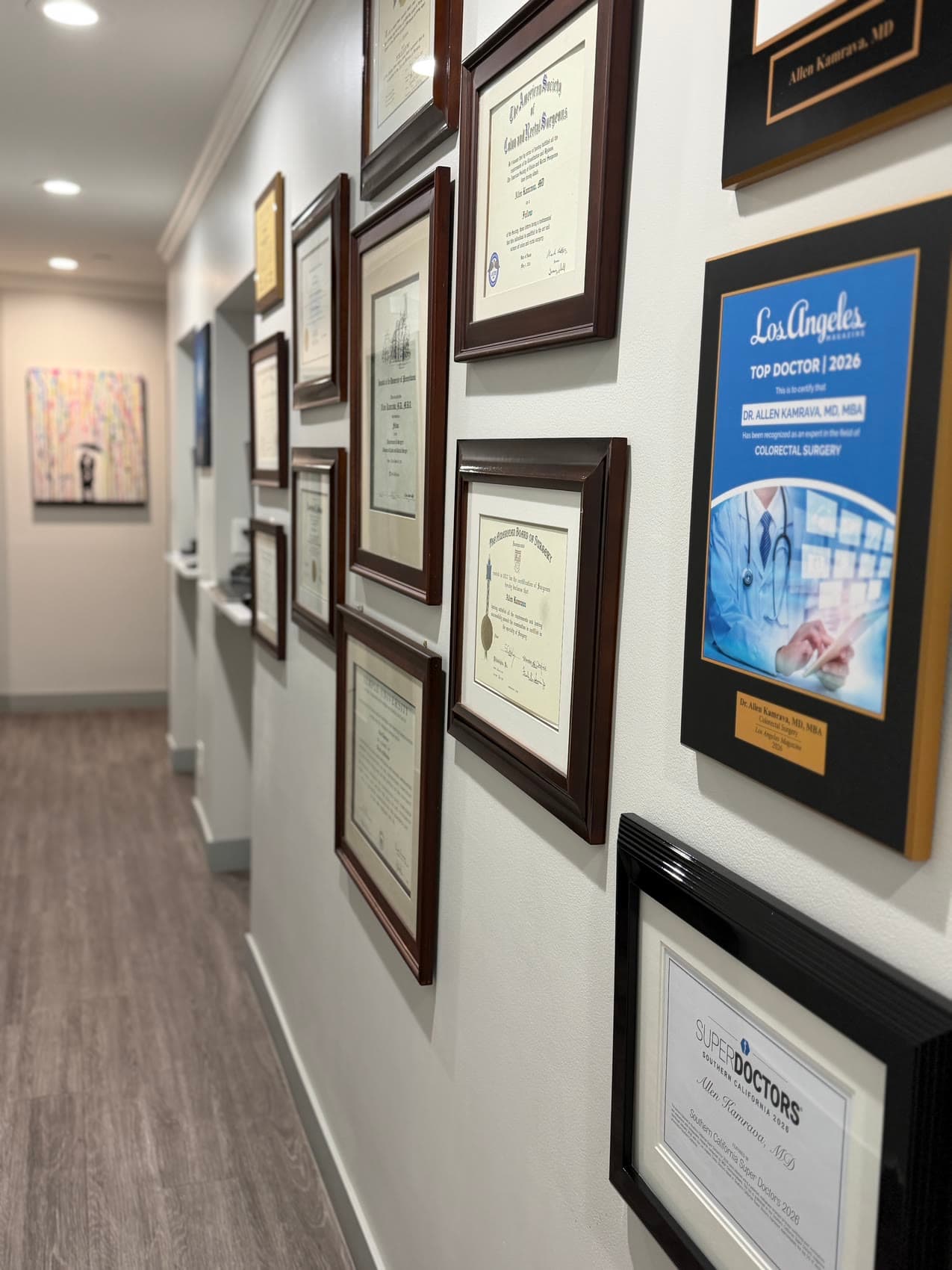 The hallway at 435 North Bedford Drive, hung with Dr. Kamrava's diplomas, American Board of Surgery and American Society of Colon & Rectal Surgeons certificates, and his Los Angeles Magazine Top Doctor and Super Doctors recognitions