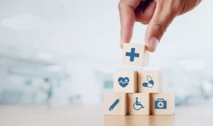 Close up man hand arranging wood block with healthcare medical icon on hospital background. Health care and Health insurance concept.